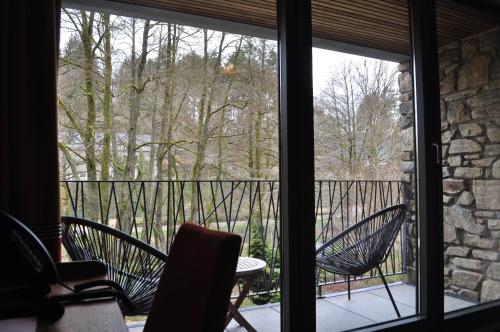 a view of a balcony with two chairs and a table at Les Terrasses de l'Our in Paliseul