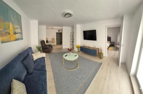 a living room with a blue couch and a table at Tudor Central Apartment in Bistriţa