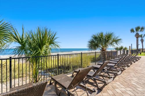 a row of chairs sitting next to the beach at Indigo in Myrtle Beach
