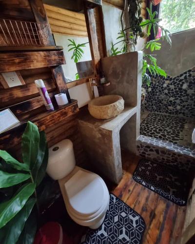 a bathroom with a toilet and a sink at Mágica Cabaña con jacuzzi en Santa Elena in Santa Elena