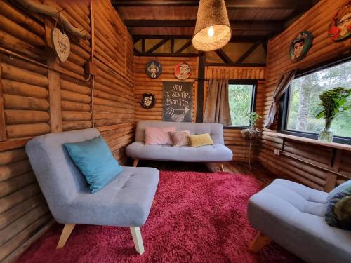 a living room with two chairs and a couch at Mágica Cabaña con jacuzzi en Santa Elena in Santa Elena
