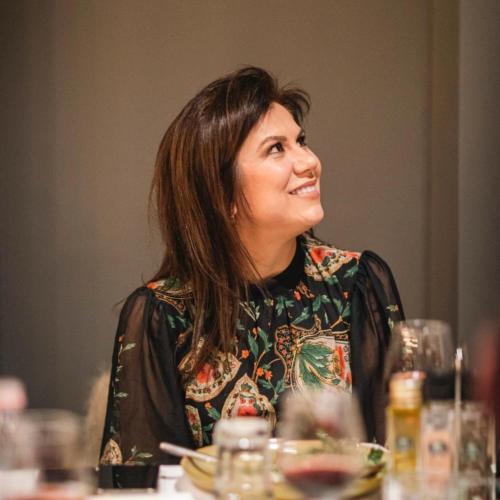 a woman sitting at a table smiling at a table at Oxygen Boutique Hotel in Tirana