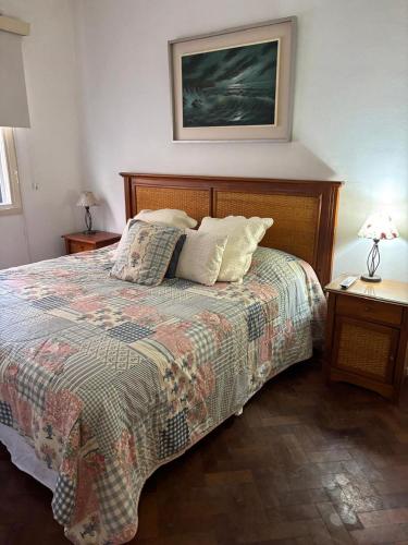- une chambre avec un lit et 2 tables avec des lampes dans l'établissement En el corazón de mendoza - Amplio departamento, à Mendoza