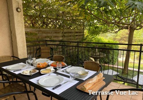 une table avec de la nourriture dessus sur un balcon dans l'établissement Maison Le Balcon du Lac, aux Salles-sur-Verdon