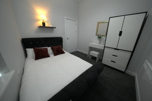 a bedroom with a bed and a dresser and a mirror at Charming Oxford Apartment in Telford - Flat 1 in Telford