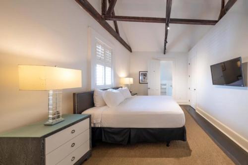 una camera da letto con un letto e una televisione di Melrose Mansion a New Orleans
