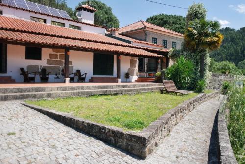 a house with a bench in front of it at Quinta de Fornelo - Família Campos in Amarante