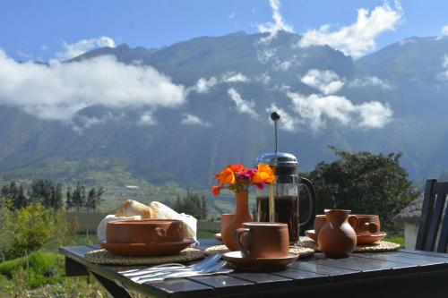 un tavolo con cibo e un vaso con dei fiori sopra di Santa Cruz Eco Lodge a Huata