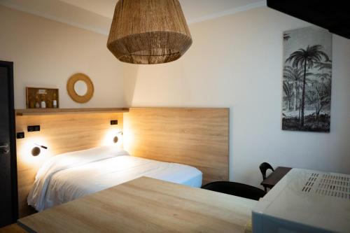 a bedroom with a bed with a wooden head board at Hôtel de la gare in Choisy-le-Roi