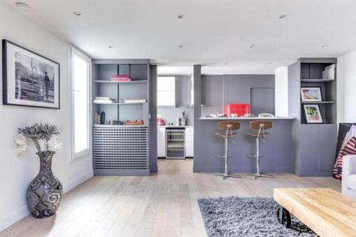 une cuisine avec des armoires violettes et un vase dans l'établissement Appartement d'Artiste, Terrasse Vue Tour Eiffel, à Paris