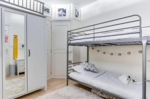 - une chambre avec 2 lits superposés et un miroir dans l'établissement Appartement d'Artiste, Terrasse Vue Tour Eiffel, à Paris