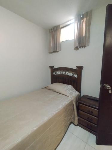 a bedroom with a bed and a dresser and a window at Gaba Hotel in Mollendo
