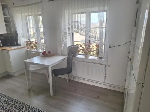 a kitchen with a table and a table and a window at Klockargården Örja byväg 17 in Landskrona