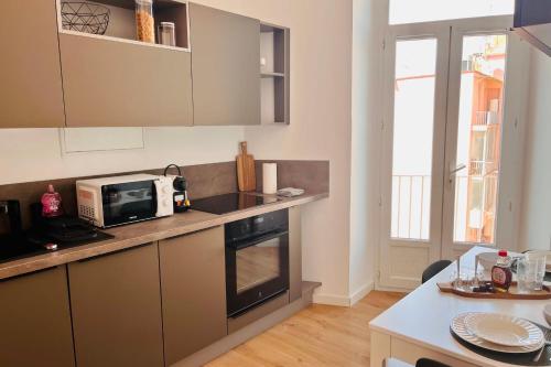 une cuisine avec un micro-ondes et une cuisinière four supérieur dans l'établissement Laure - Luminous Cozy Sampiero - by TGB, à Ajaccio