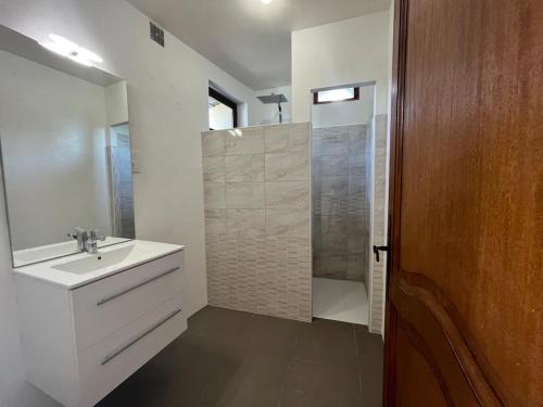 Un baño blanco con lavabo y ducha. en La rive du Viaur, en Pampelonne