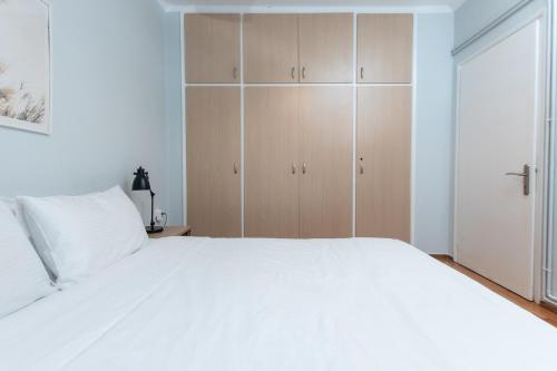 a bedroom with a large white bed and wooden cabinets at Houseloft White Tower Icon in Thessaloniki