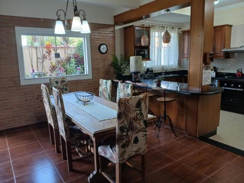 a kitchen with a table and chairs and a kitchen with a counter at Chalet Rustico da Elena com Sauna y Jacuzzi Unicep in São Carlos