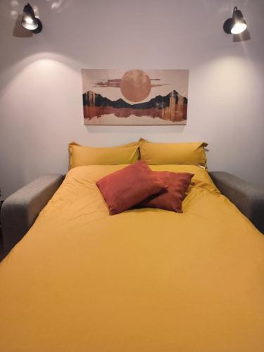 - une chambre avec un lit jaune et 2 oreillers dans l'établissement ô vive studio, à Monnetier-Mornex