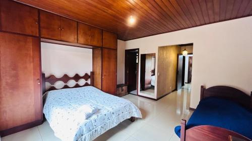 a bedroom with a bed and a mirror in it at Casa na serra in Campos do Jordão