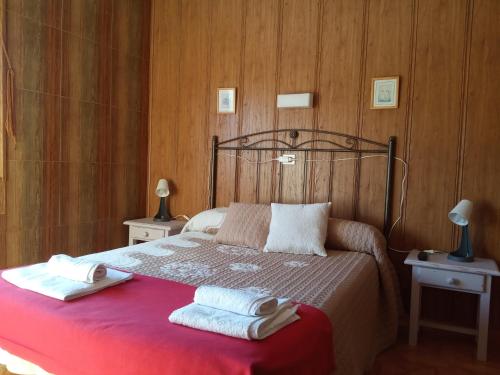 Un dormitorio con una cama con dos toallas encima. en Hostal La Collada de Aralla, en Aralla de Luna
