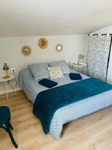 une chambre avec un grand lit avec une couverture bleue dans l'établissement L'Ostalet, à Saint-Marcel-dʼArdèche