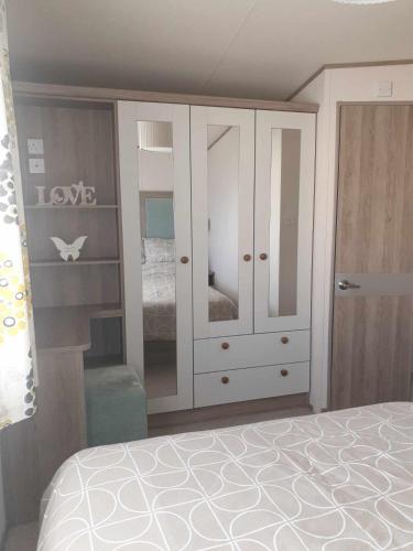 a bedroom with a white cabinet and a bed at Agnes Place in Nairn