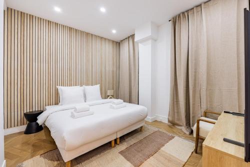 une chambre avec un grand lit blanc et une télévision dans l'établissement Elegant 1BR - Muette - Auteuil, à Paris