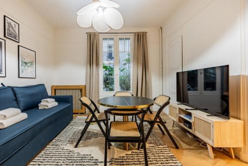 un salon avec un canapé bleu et une table dans l'établissement Elegant 1BR - Muette - Auteuil, à Paris