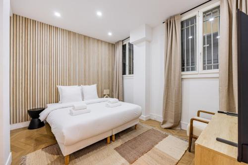une chambre avec un lit blanc et une fenêtre dans l'établissement Elegant 1BR - Muette - Auteuil, à Paris