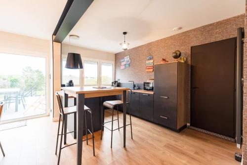 a kitchen with a table and a refrigerator at Maison avec terrasse proche plage et port de Binic in Binic-Etables-sur-Mer