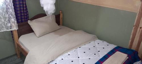 a white bed with a wooden headboard and a pillow at Mara Sidain safaris in Sekenani