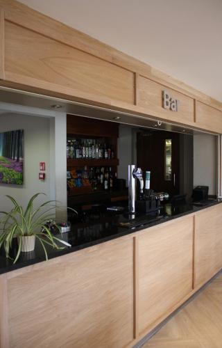 a bar in a restaurant with a bar counter at Stoneleigh Park Lodge in Leamington Spa