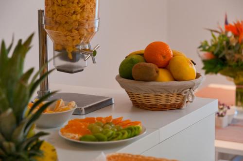 a basket of fruit on a counter with a bowl of oranges at Villa Paulina in Brela