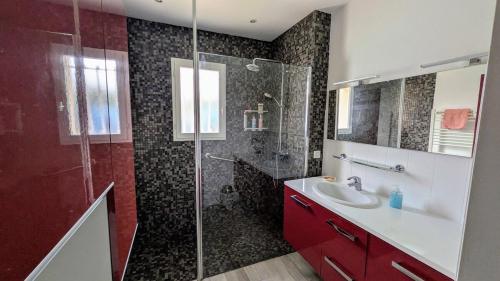 une salle de bain avec une douche et un lavabo et une cabine de douche en verre dans l'établissement Maison avec piscine quartier pinède de conteau, à La Teste-de-Buch