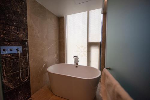 a bath tub in a bathroom with a window at The One Boutique Hotel in Queens