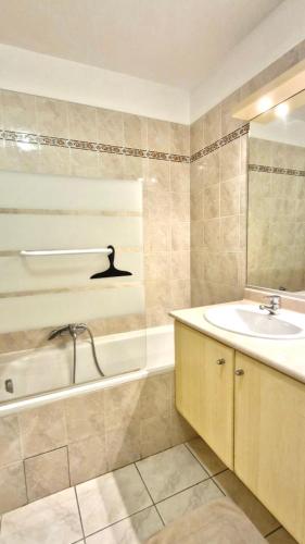 une salle de bain avec une baignoire et un lavabo et une baignoire dans l'établissement T3 dans une résidence de vacances, à Fréjus