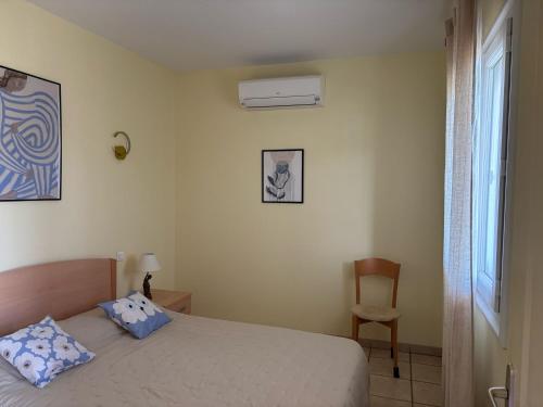 a bedroom with a bed and a chair and a window at Résidence Villa Romana avec spa in Propriano