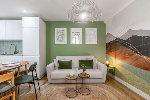 un salon avec un canapé blanc et une cuisine dans l'établissement B42#République#Marais#1BedRoom#Paris03#AC, à Paris