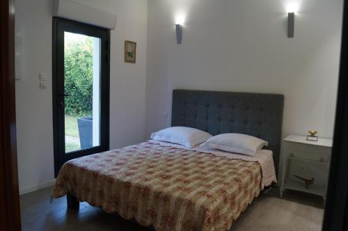 1 dormitorio con 1 cama y puerta a un patio en Le Cherche Midi, entre Nîmes, le Pont du Gard, Uzès, Arles, en Marguerittes