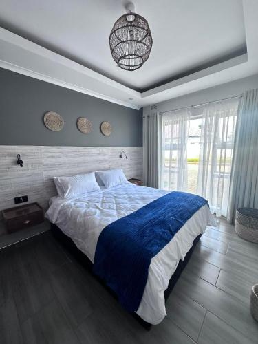 a bedroom with a large bed with a blue blanket at lush apartments in Lilongwe