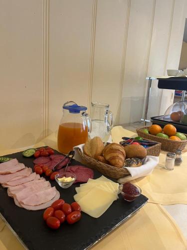 a table with meat and vegetables on a cutting board at AR Boutique Hotel Mannheim in Mannheim
