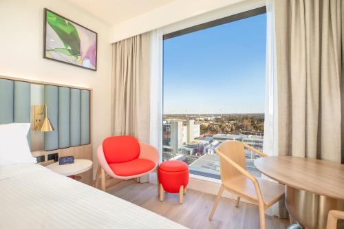 a hotel room with a bed and a table and chairs at Holiday Inn & Suites Geelong by IHG in Geelong