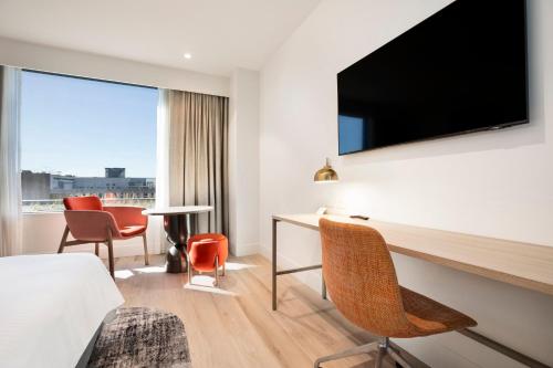 a hotel room with a bed and a flat screen tv at Holiday Inn & Suites Geelong by IHG in Geelong