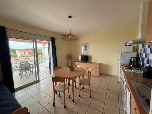 a kitchen with a table and a dining room at Résidence Villa Romana avec spa in Propriano