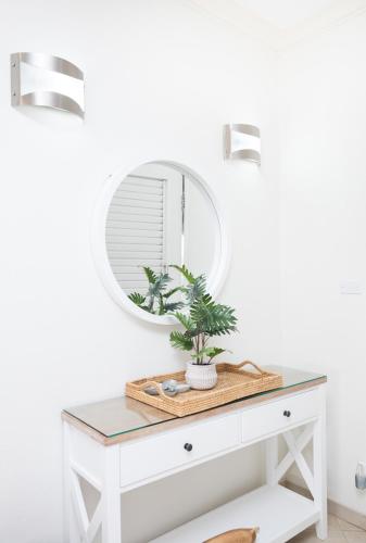 a white dressing table with a mirror and a plant on it at Sugar Hill Estate - B307 by Island Villas in Saint James