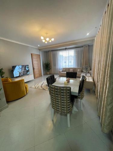a living room with a table and chairs and a couch at Posh Apartment Munyonyo in Kampala
