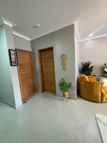 a living room with a yellow couch and a door at Posh Apartment Munyonyo in Kampala