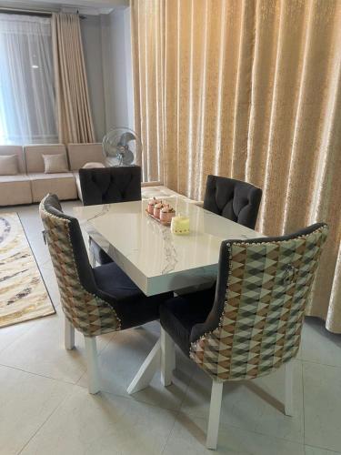 a dining room table with two chairs and a couch at Posh Apartment Munyonyo in Kampala