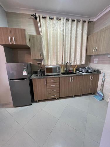 a kitchen with a refrigerator and a microwave in it at Posh Apartment Munyonyo in Kampala