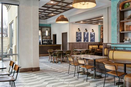 a restaurant with tables and chairs and a bar at Sol Cypress, San Antonio, a Tribute Portfolio Hotel in San Antonio